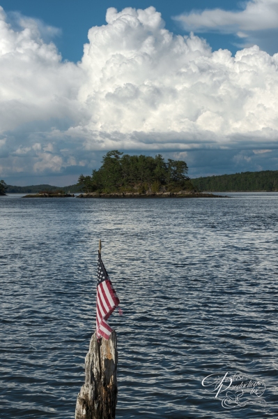US Flag on Rotting Mooring Point with Island in Distance